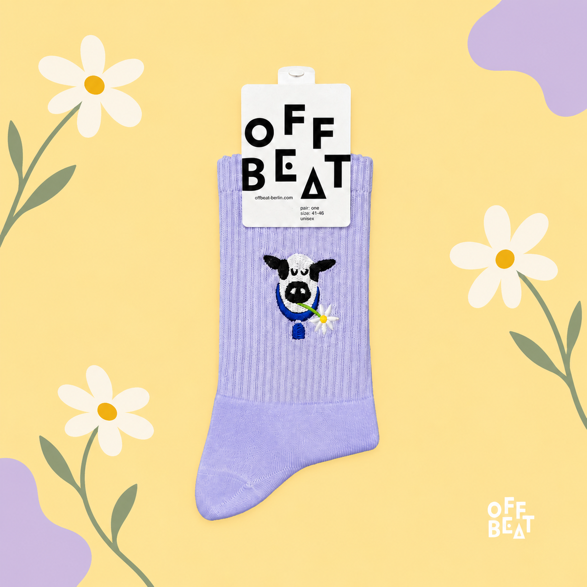 Lavender embroidered Swiss cow socks on a yellow meadow-inspired background with daisies